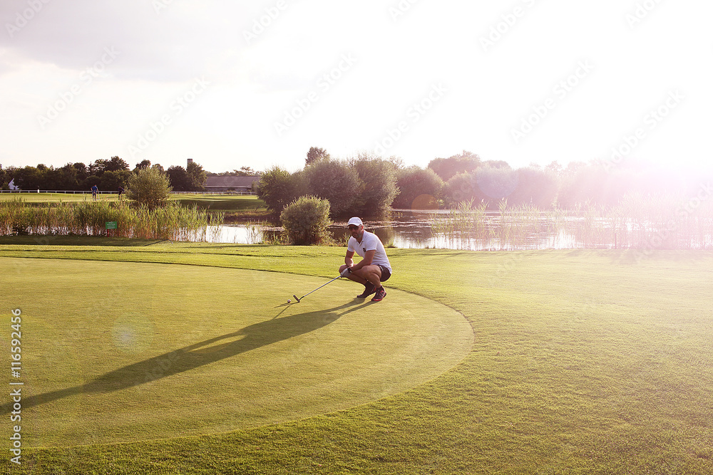 Obraz premium Golfiści na putting greenie o zachodzie słońca