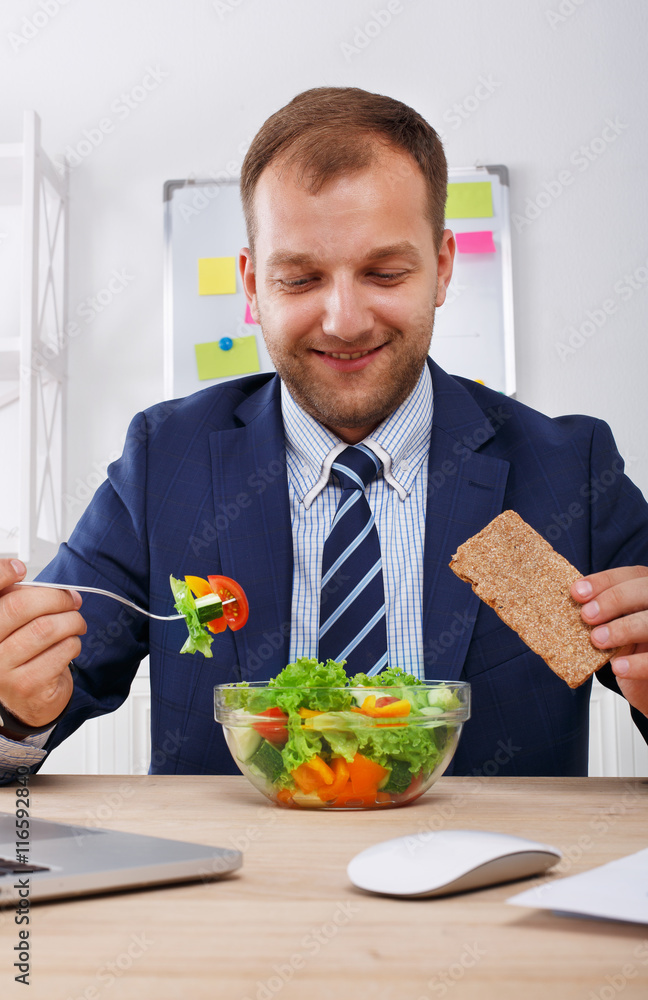 Man has healthy business lunch in modern office interior Man has healthy business lunch in modern office interior