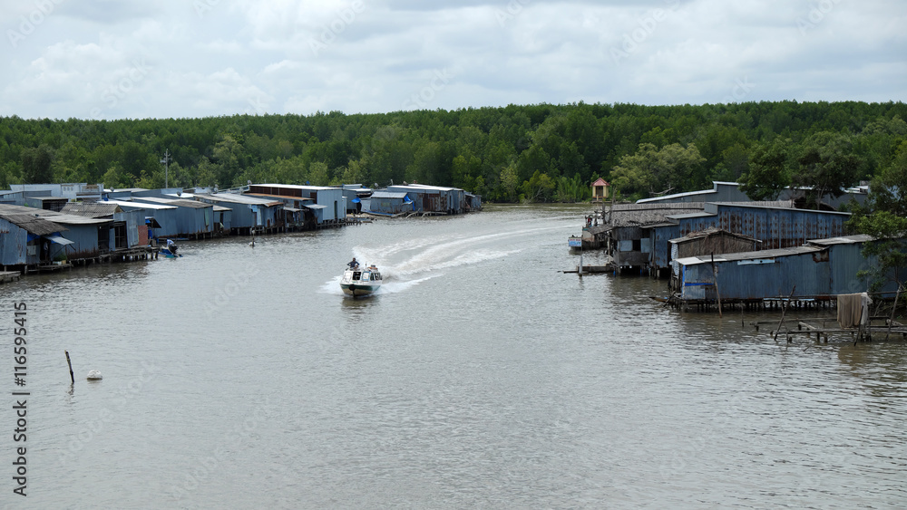 Ca Mau riverside residential with motor boat Ca Mau riverside residential with motor boat