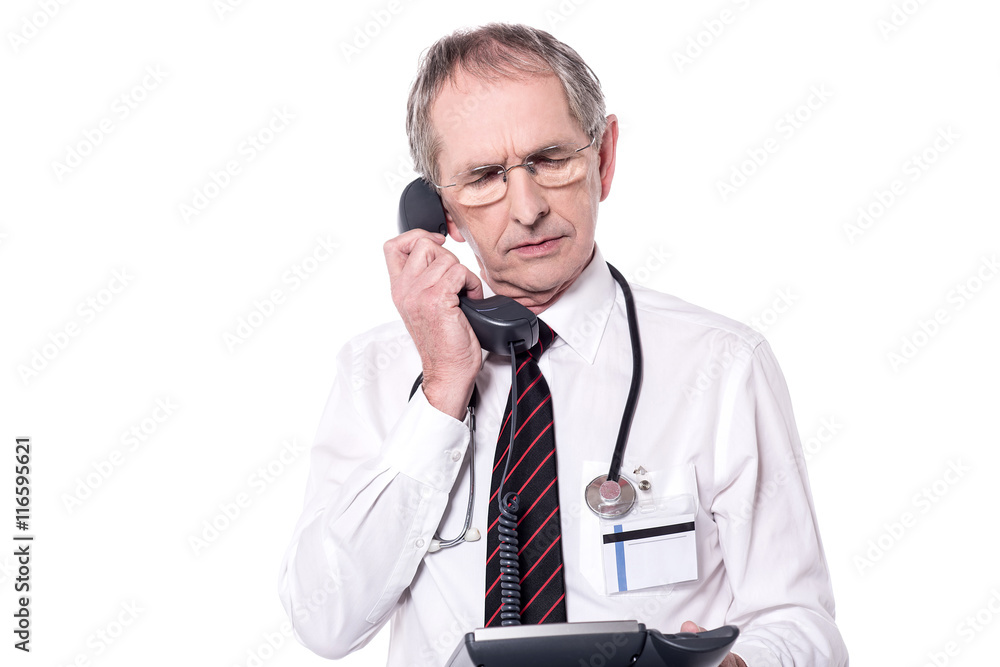 Senior physician answering a phone call Senior physician answering a phone call