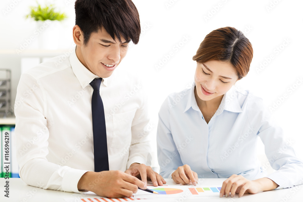 business man and woman discussing doucment in office business man and woman discussing doucment in office