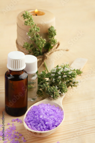 Essential oil with aromatic salt on a wooden background. The concept of aromatherapy.