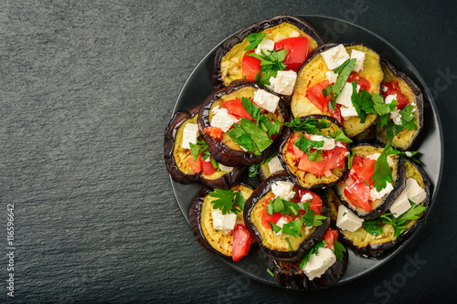 Appetizers - grilled eggplants with garlic, feta cheese and tomatoes.