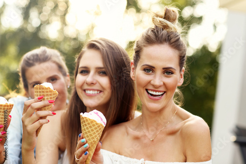Happy group of friends eating ice-cream outdoors