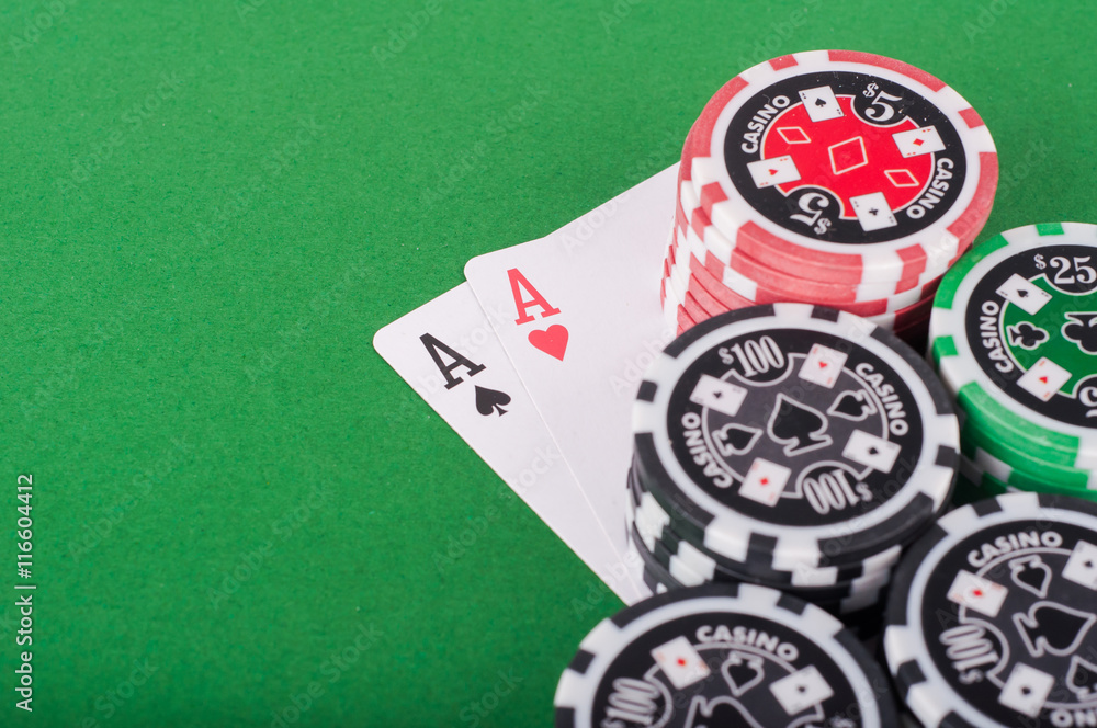 Fototapeta premium pair of aces, red and black cassino chips on green table