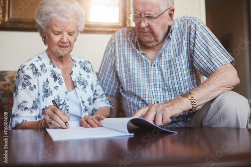Senior husband and wife doing paperwork together at home