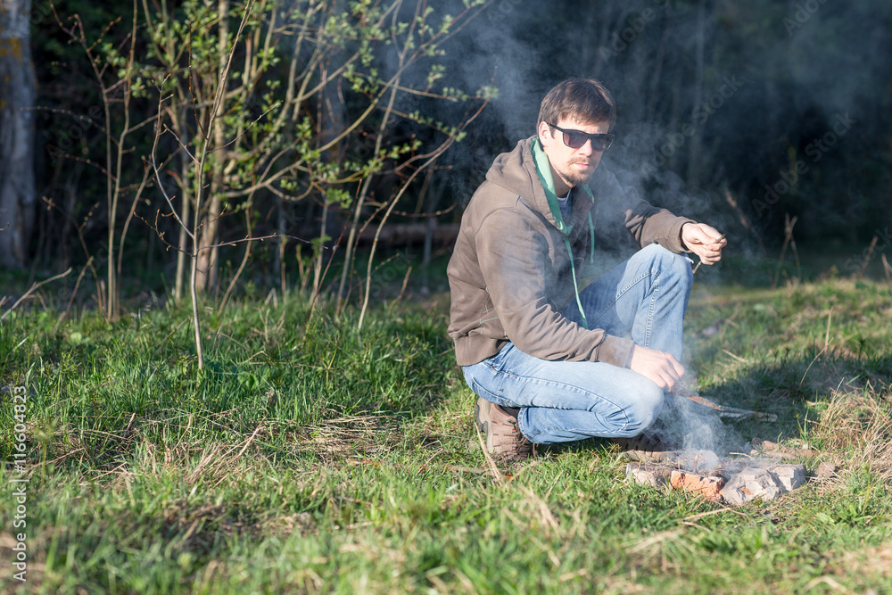 man at a picnic by the bonfire man at a picnic by the bonfire