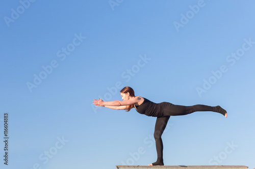Young woman doing yoga on the roof