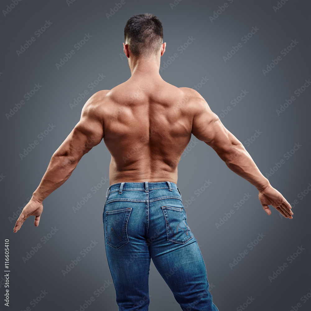 Male bodybuilder flexing his back muscles on grey background Stock Photo