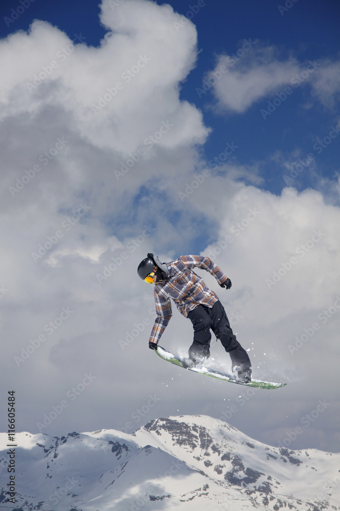 Snowboarder jumps high in the mountains.