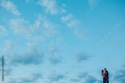 Love story . Couple at sunset. On the background of the sky. Clouds.