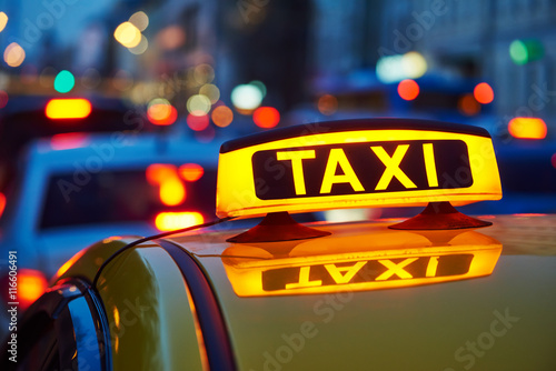 taxi sign on car at evening in the city street
