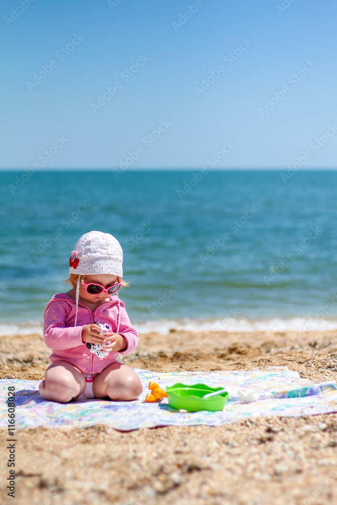 Baby girl playing on the beach near the sea Baby girl playing on the beach near the sea
