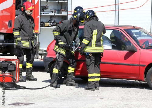 Firefighter opens car door with pneumatic shears