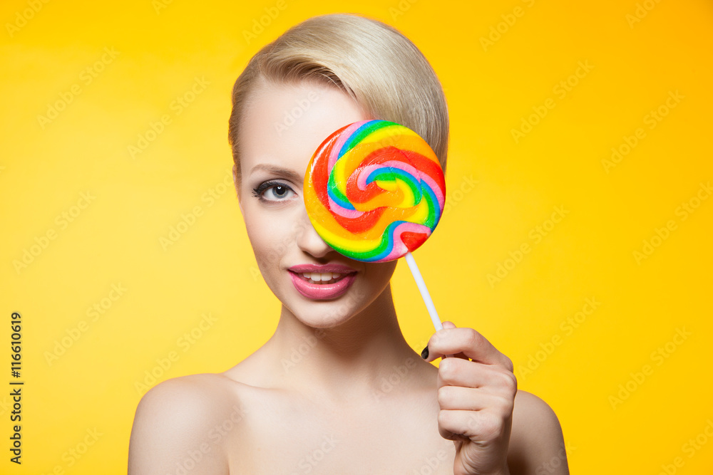 Cheerful blondie with lollipop covering eye