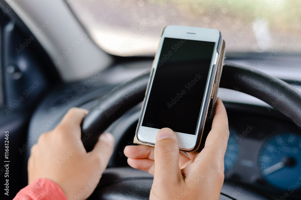 Car driver using smart phone, closeup on hand, mockup screen background