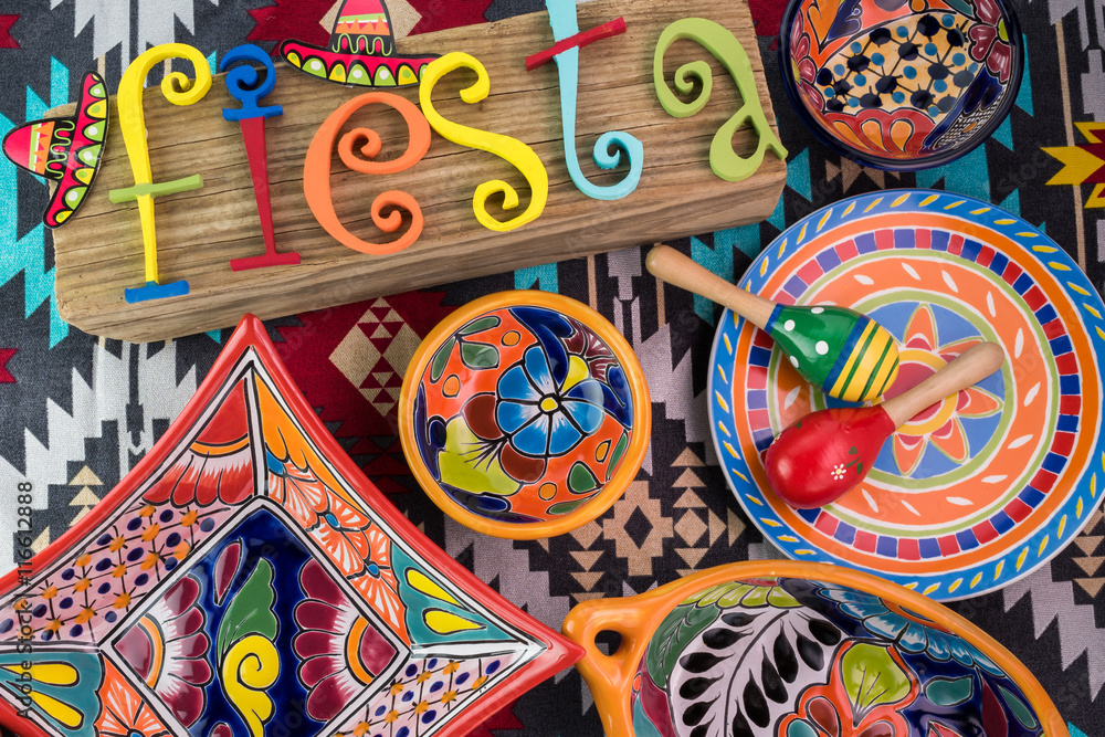 Mexican fiesta table decoration with  colorful painted letters, bright pottery, maracas.