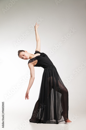 Young ballet dancer wearing black transparent dress dancing 