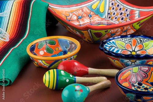 Mexican fiesta table decoration with colorful bright pottery, traditional table runner, maracas.