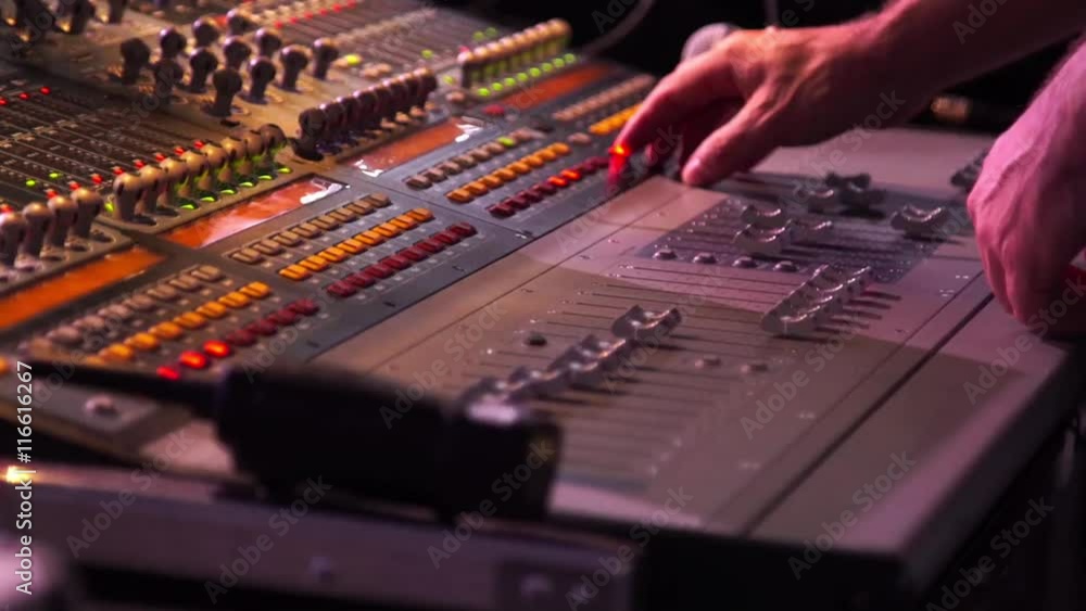 Male hands using a sound digital mixer at a concert on stage background Male hands using a sound digital mixer at a concert on stage background