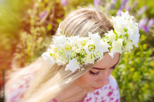 Fotografi Flower coronet on the head of a young blond girl