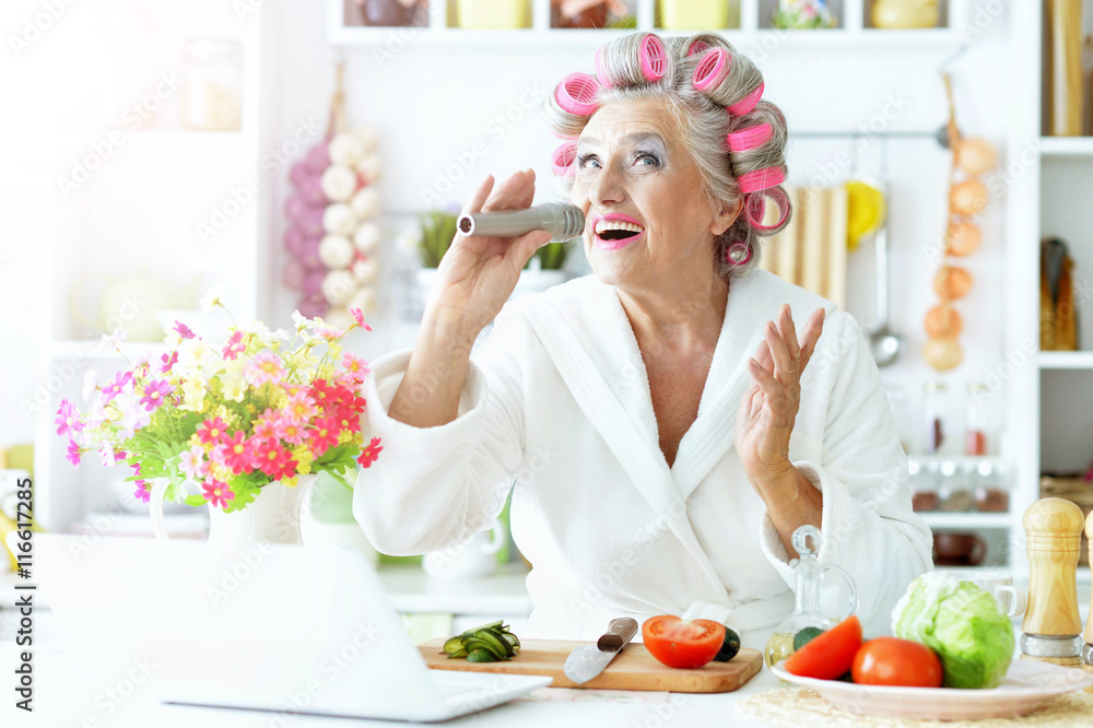 Senior woman in hair rollers at kitchen Senior woman in hair rollers at kitchen