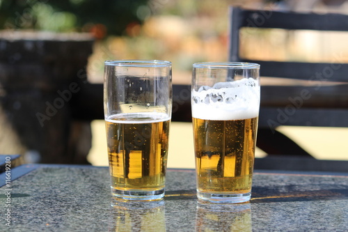 Two glasses of draught beer on a marble table