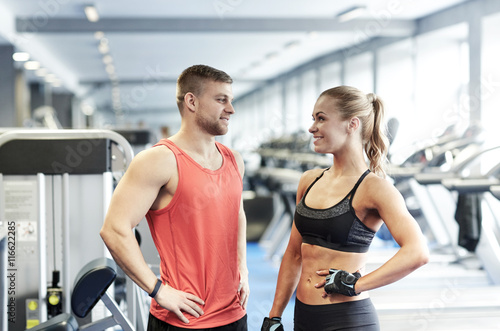 smiling man and woman talking in gym