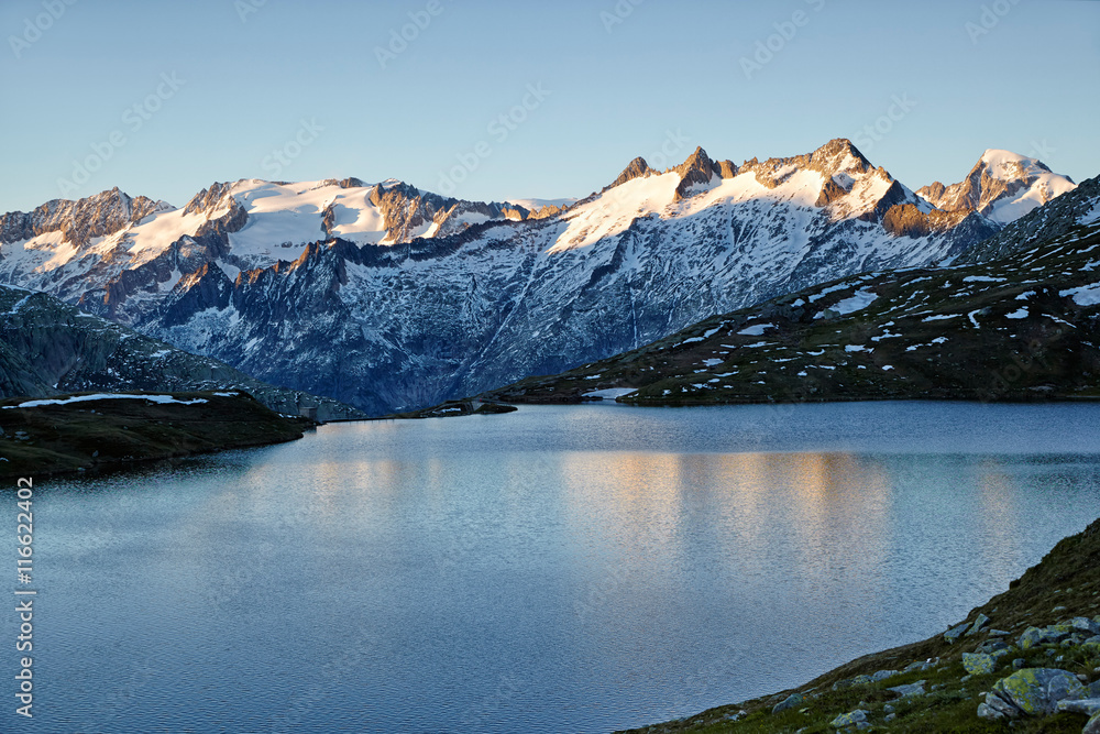 Triebtenseewli, iyllischer Alpensee mit Blick auf verschneite Gebirgskette in der Abendsonne, Wasserspiegelungen