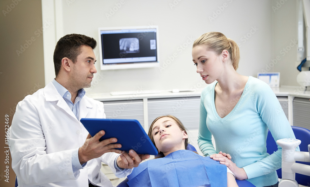 Fototapeta premium dentist showing tablet pc to girl and her mother
