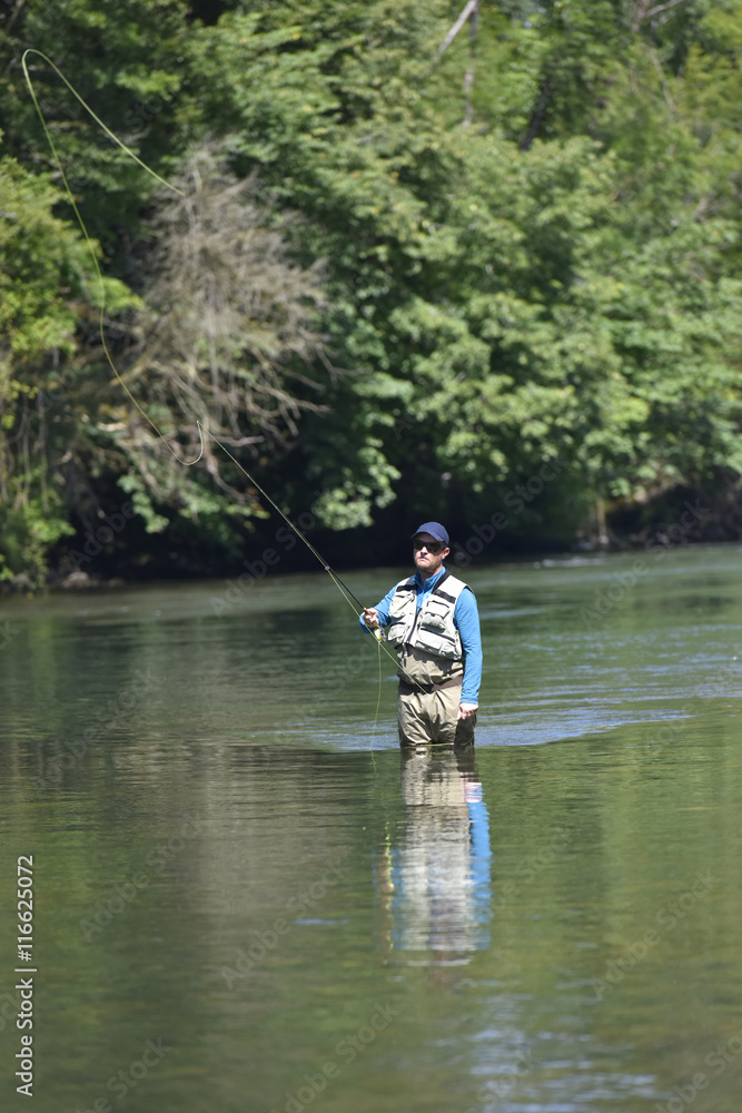 Flyfisherman fishing in mountain river Flyfisherman fishing in mountain river