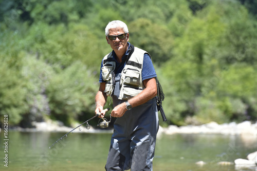 Fisherman cast fishing in mountain river