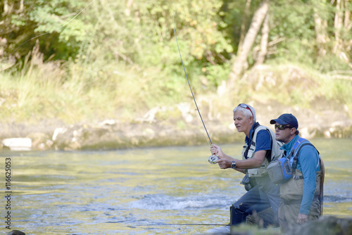 Flyfisherman with fishing guide in river