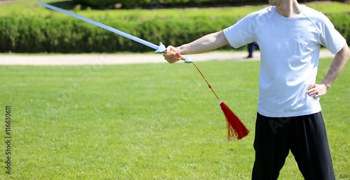 Tai Chi martial arts athlete expert makes motions with sword