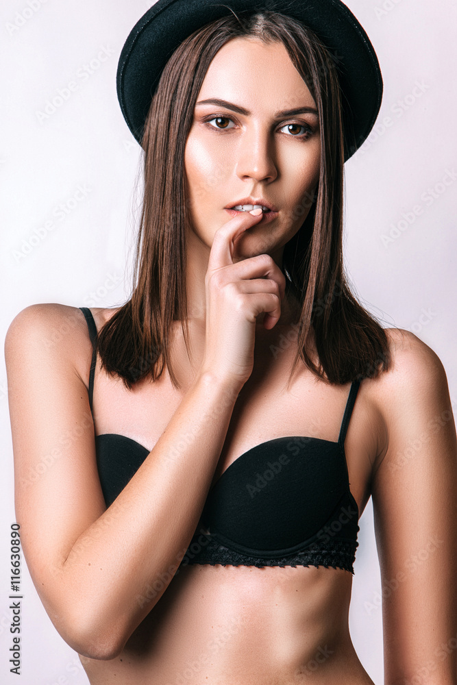 Photo of beautiful woman in a black fashion hat. Studio portrait. Photo of beautiful woman in a black fashion hat. Studio portrait.