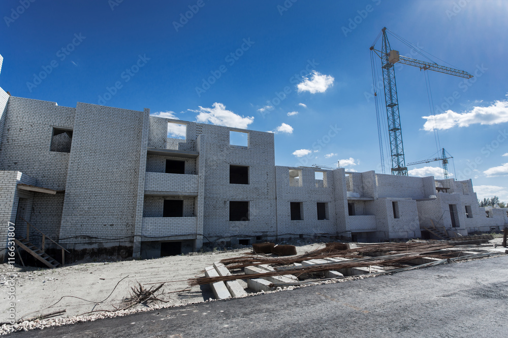 Fototapeta premium Crane construction bricks concrete building in city