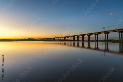 Beautiful sunset scene of railway bridge in lake of pasak Dam , © martinhosmat083