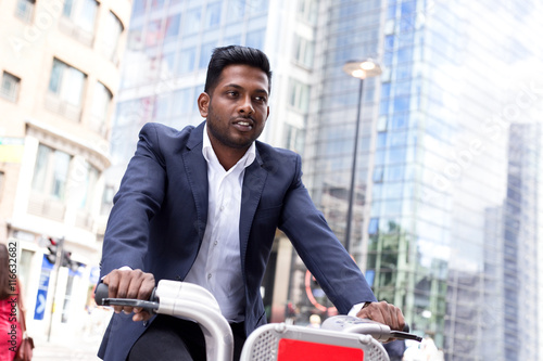 Indian business man riding a london hire bike
