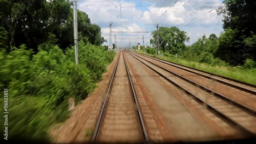 Railroad tracks in summer nature behind a passing train photo