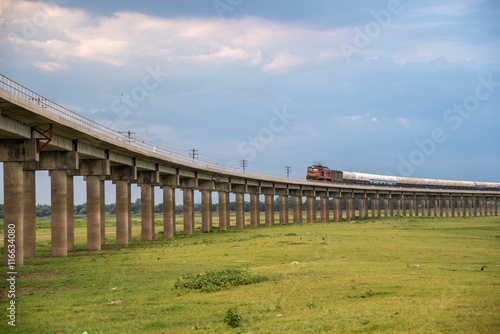 Train on the railway cross grass field meadow at Pasuk River Dam © martinhosmat083