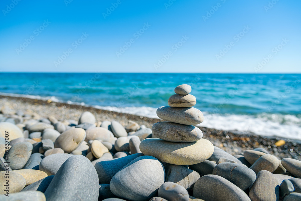 Naklejka Medytacja z kamienną wieżą na brzegu morza
