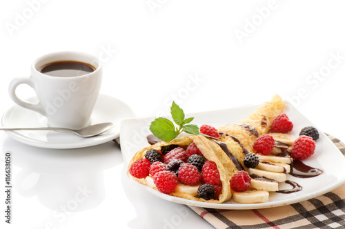 Cup of coffee and pancakes with berries