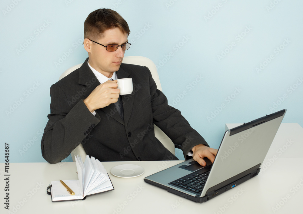 Businessman reads news online and drinking coffee Businessman reads news online and drinking coffee