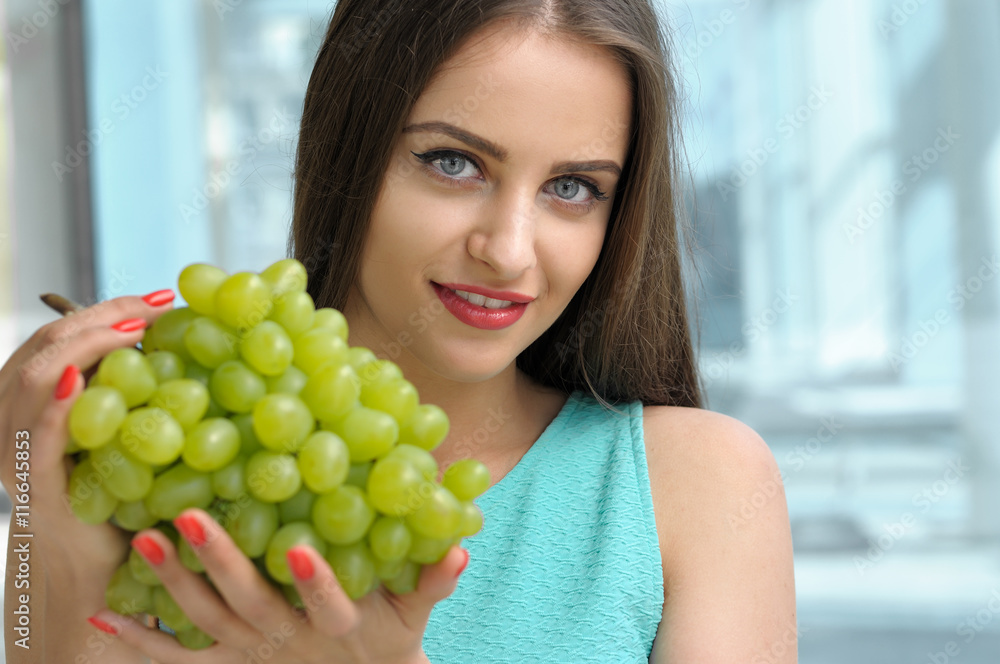 Beautiful girl holding a bunch of ripe grapes Beautiful girl holding a bunch of ripe grapes