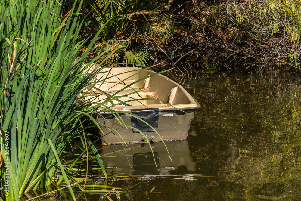 empty boat and its reflection in quiet water in forest empty boat and its reflection in quiet water in forest