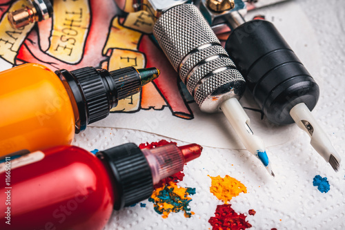 Fotografie Replacement supplies for tattoo in sterile packages, sketches, inks and a tattoo