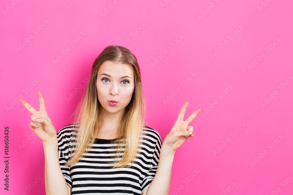 Young woman giving the peace sign Young woman giving the peace sign