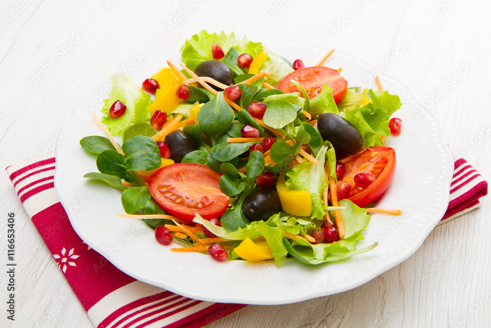 mixed salad with tomatoes in white plate on wood table mixed salad with tomatoes in white plate on wood table