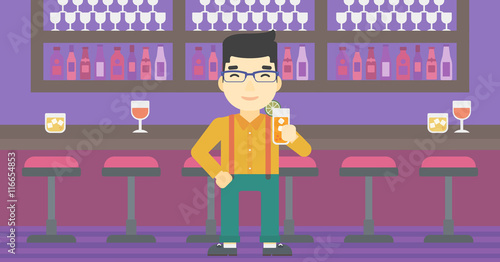 Man drinking orange cocktail at the bar.