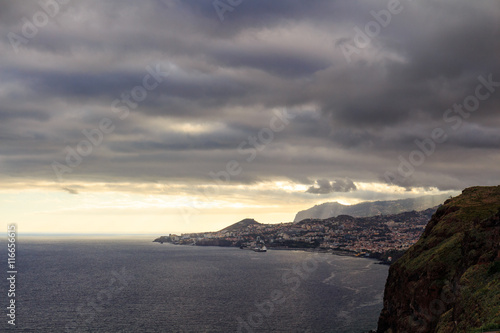 Funchal coastline under the typical cloudy sky before sunset.